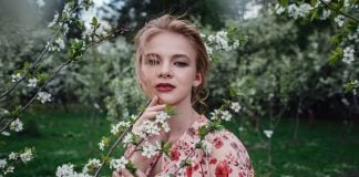 Young beautiful woman in the cherry-blossoming garden.